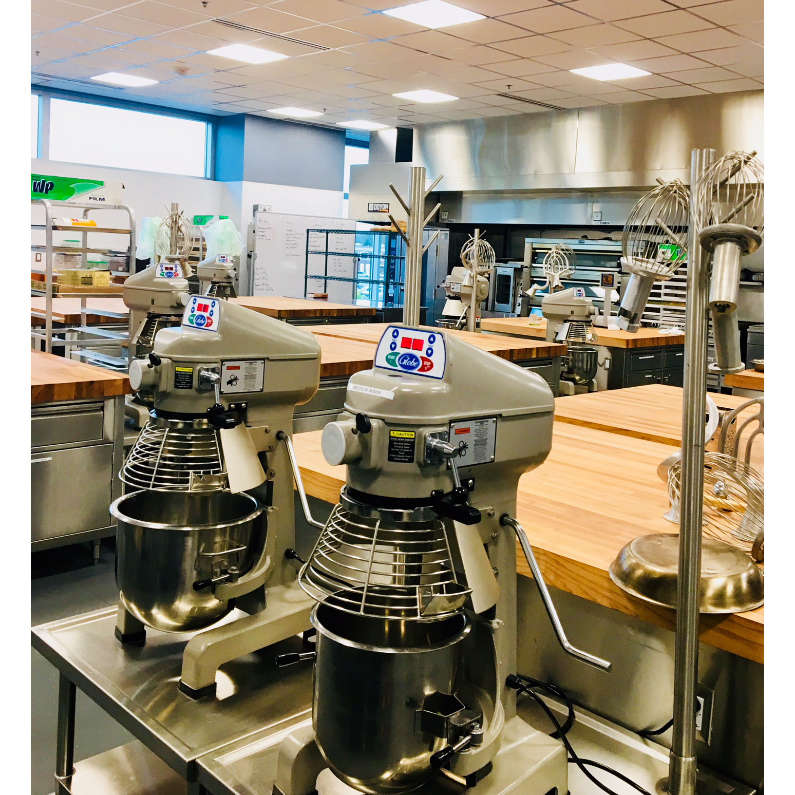 Two kitchen stand mixers on a counter.