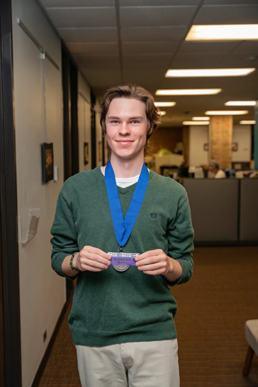 Photo of Adrien Simmons holding the award