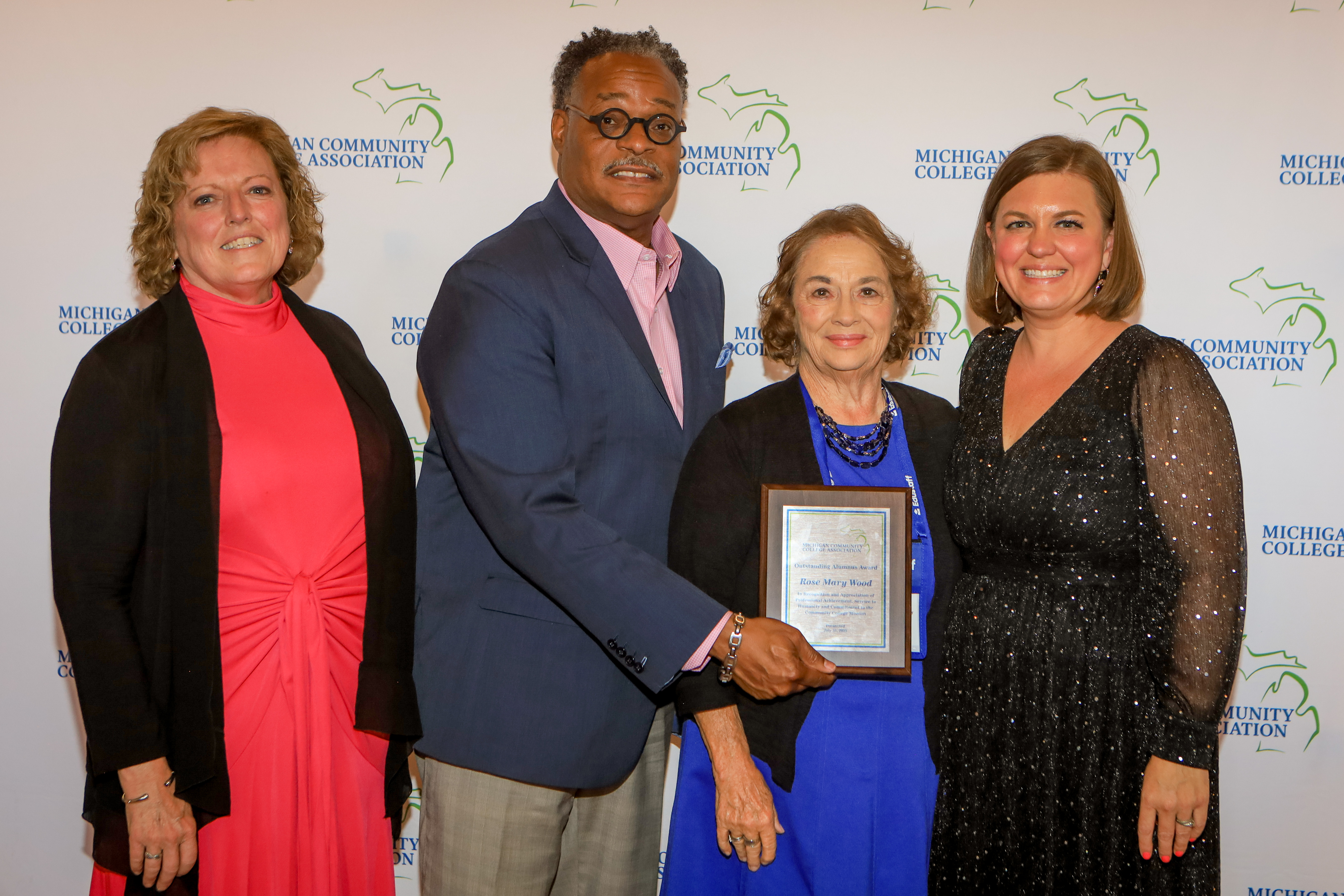 Group photo including award winner Rose Mary Wood and Kalamazoo Valley president L. Marshall Washington pose with an award plaque