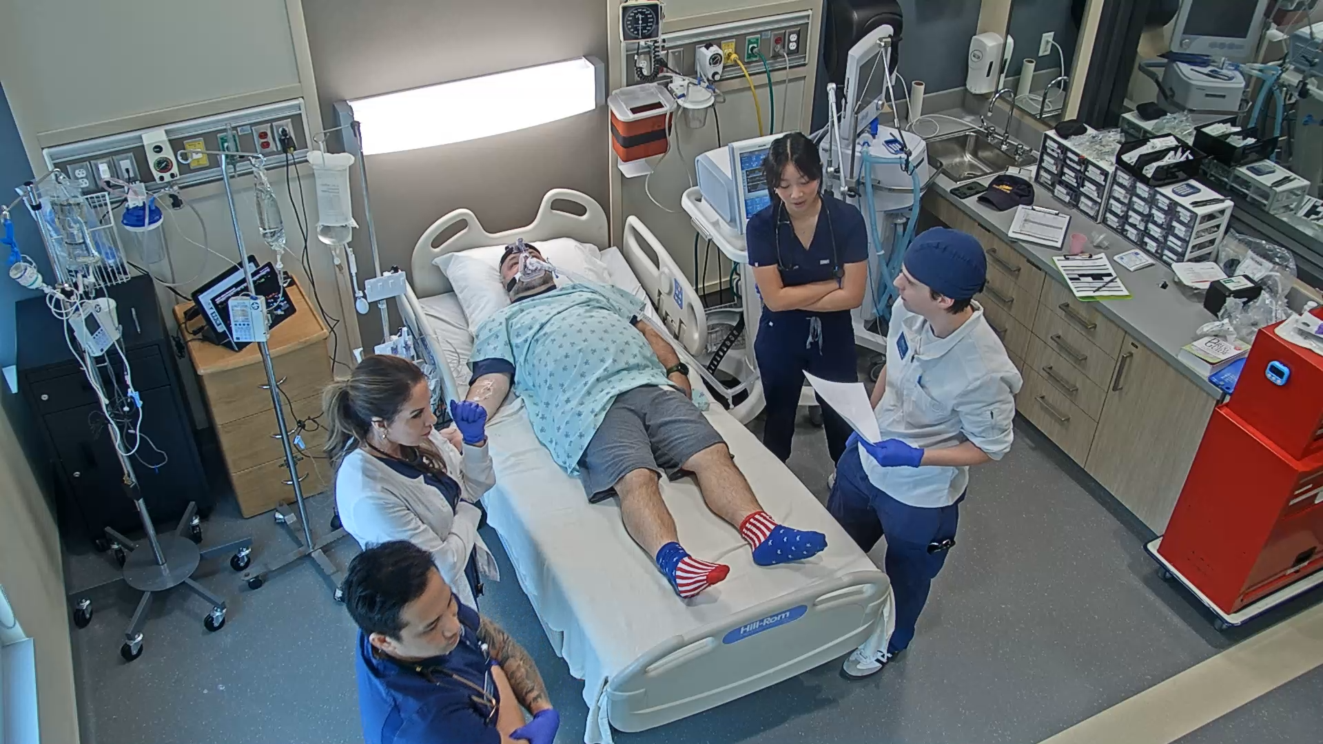Nursing and RCP students gathered around a hospital bed as part of simulation training.